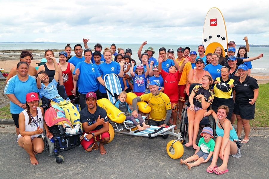 WaterWheels floating beach wheelchair with a group at the beach