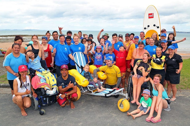 WaterWheels floating beach wheelchair with a group at the beach